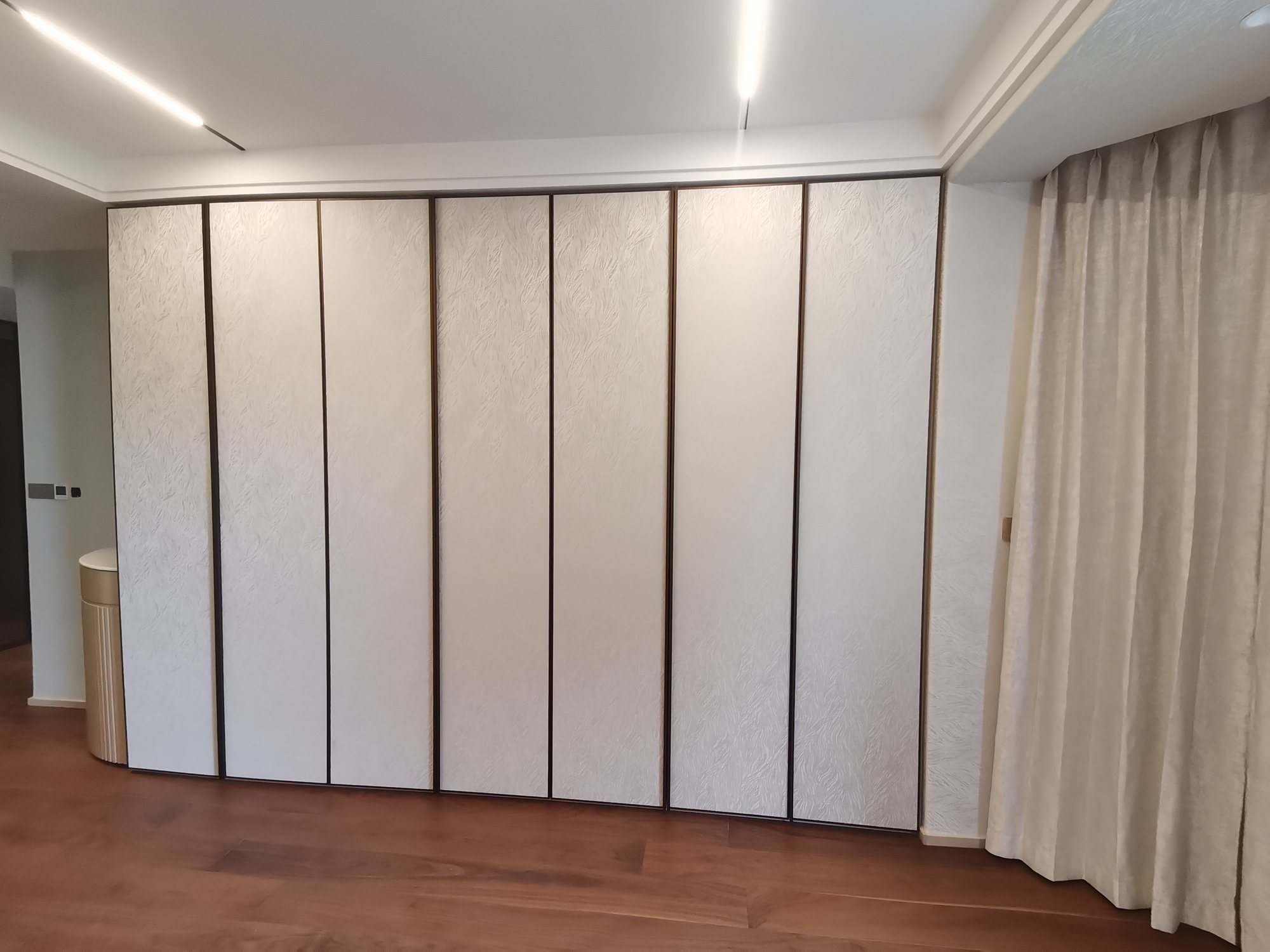 Bedroom full-wall custom wardrobe with textured decorative panels
