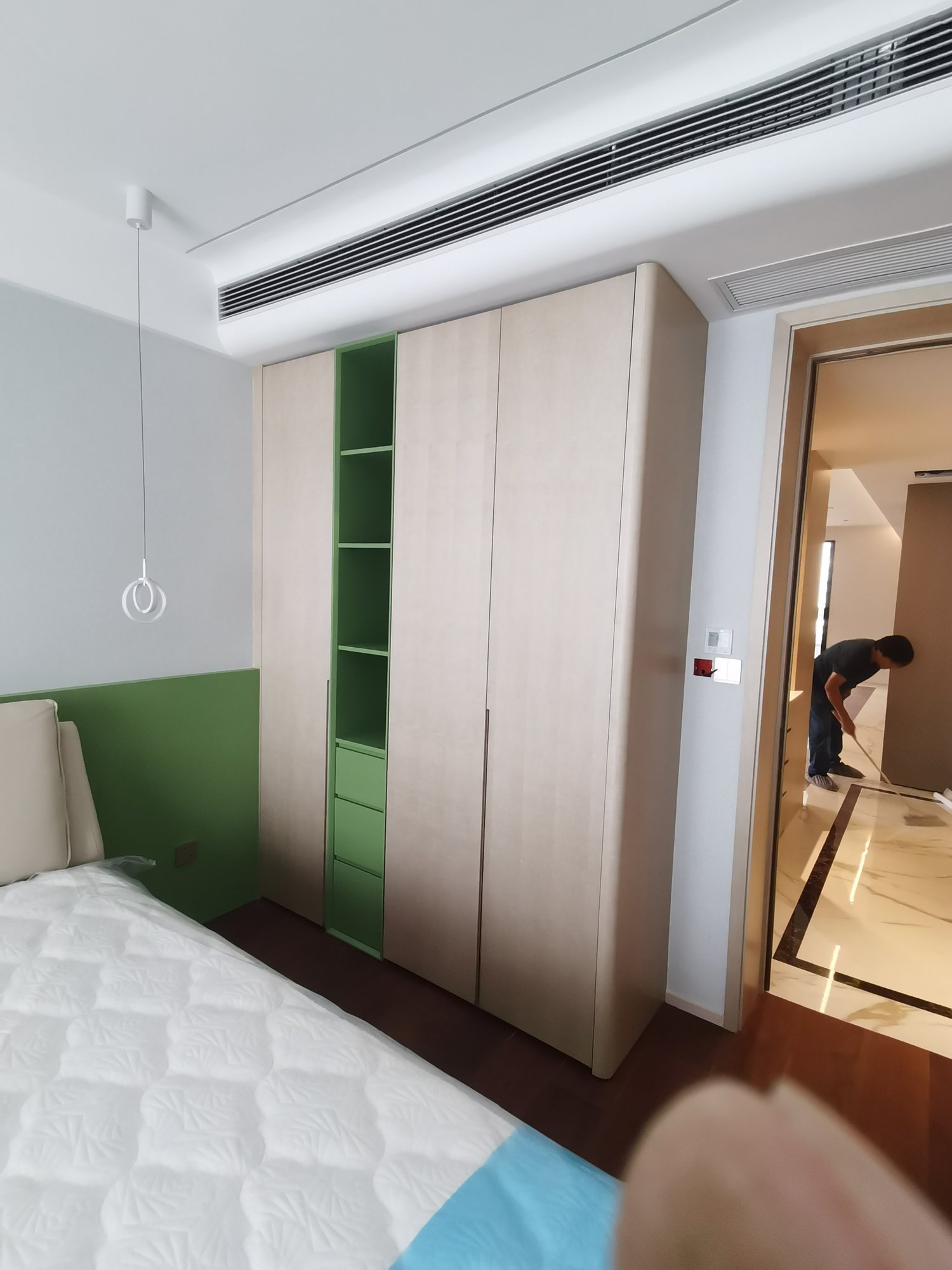 Bedroom custom wardrobe in light wood tone with green open shelving