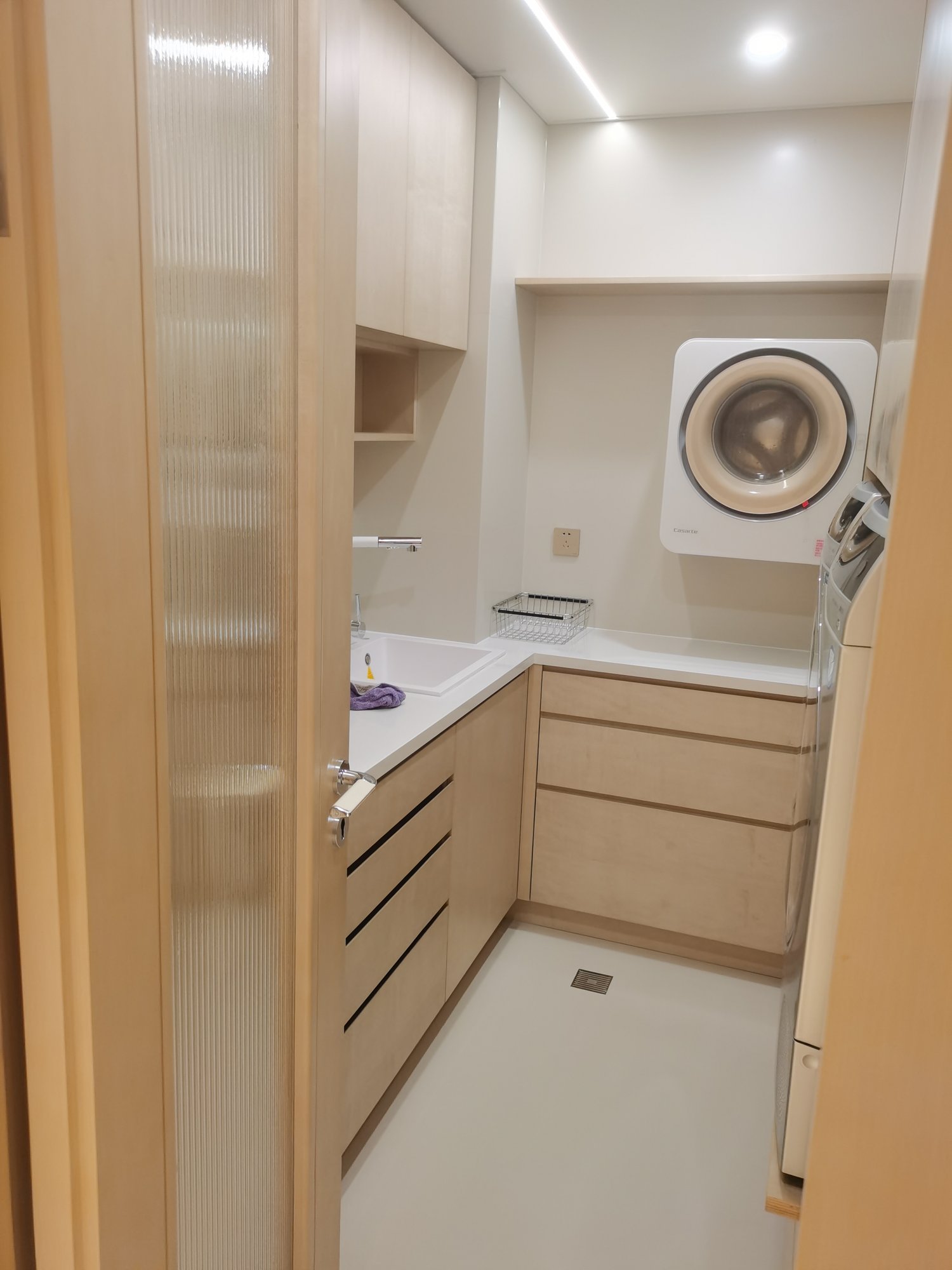 Laundry room custom laundry cabinet and upper cabinet with sink and wall-mounted washing machine