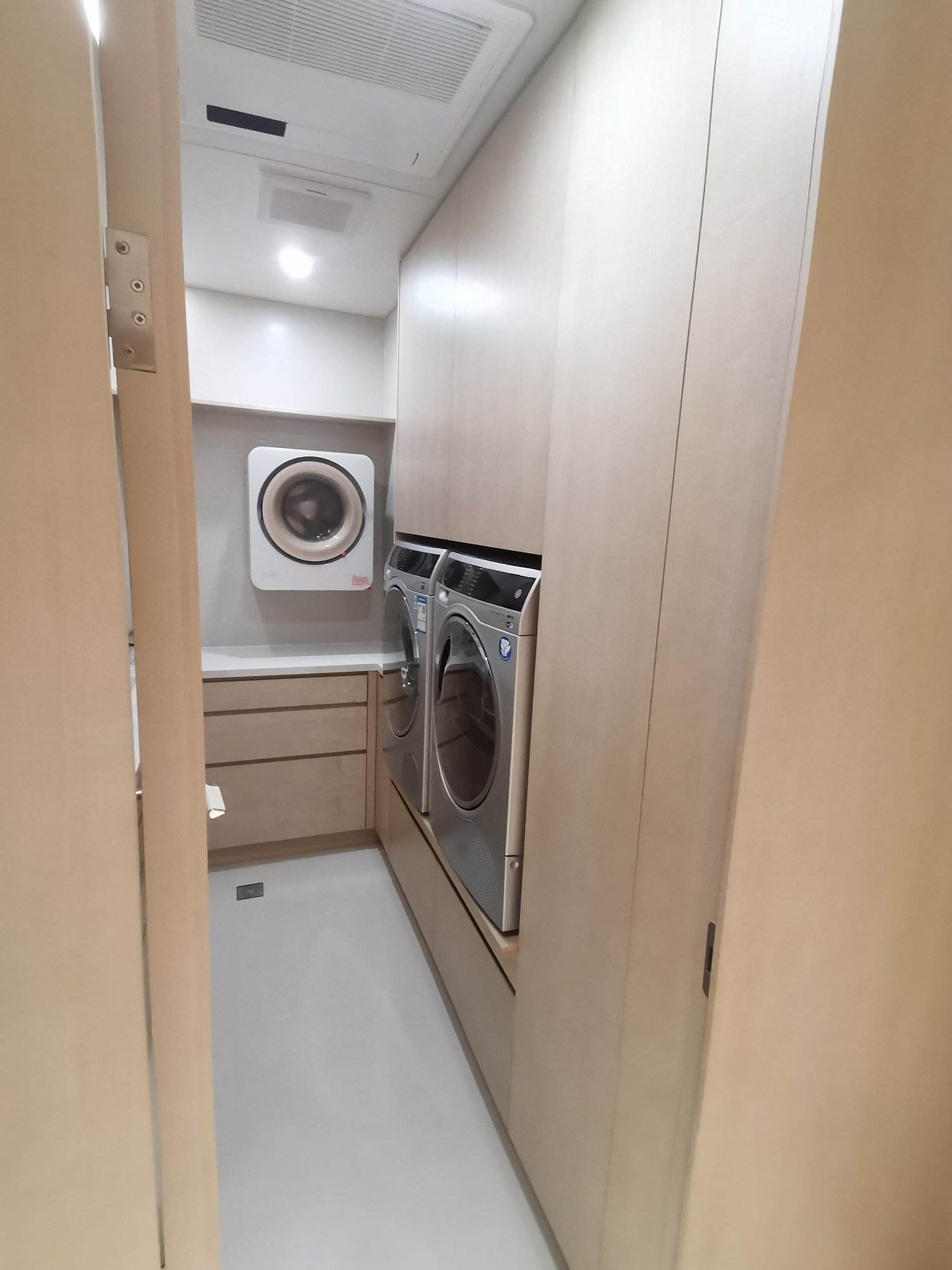 Laundry room custom cabinetry for washer and dryer with wall-mounted washing machine
