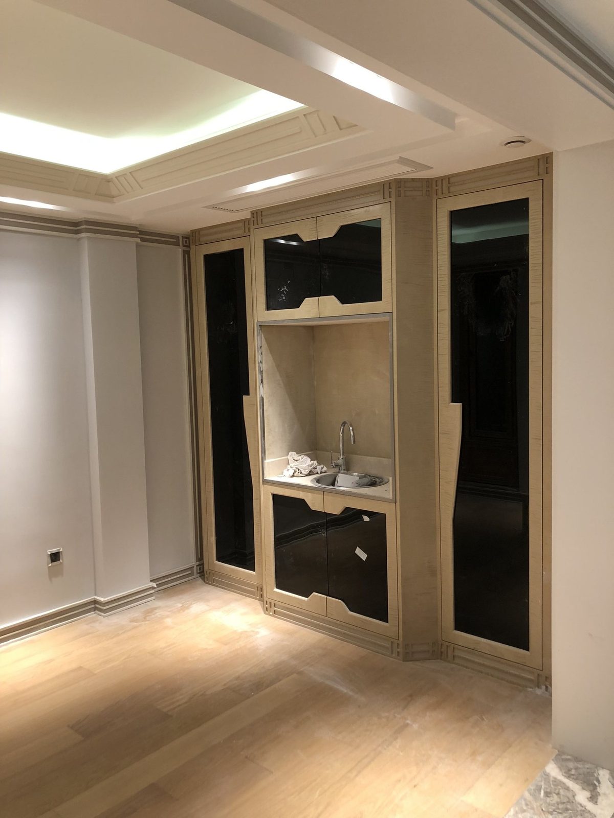 Entry custom display cabinet with sink and glass doors.