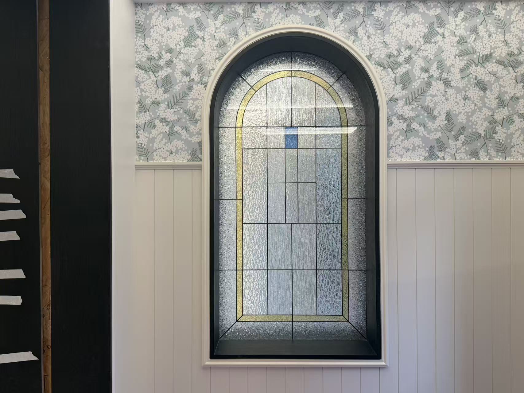 Entryway with arched glass window and wall paneling