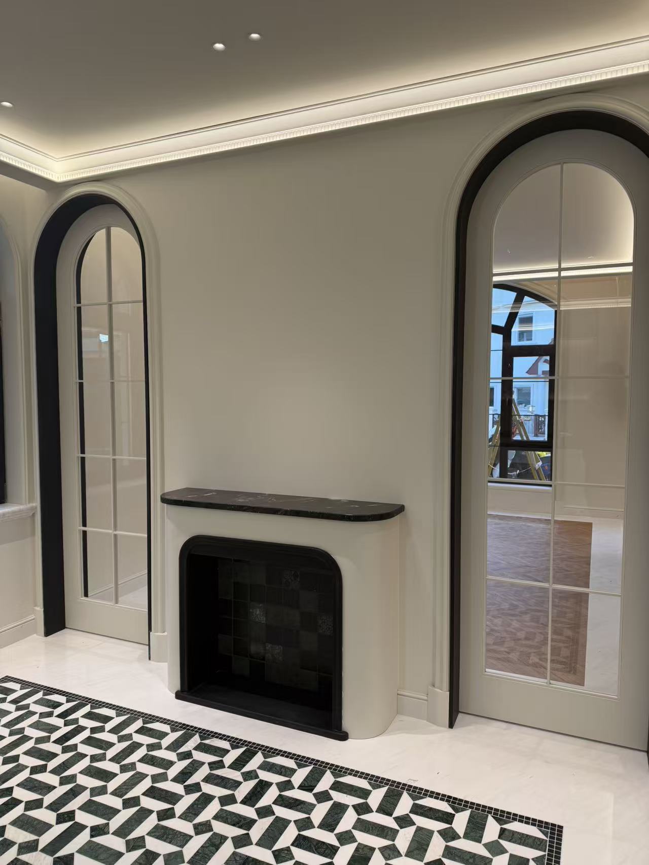 Living room with fireplace cabinetry and arched glass-panel doors