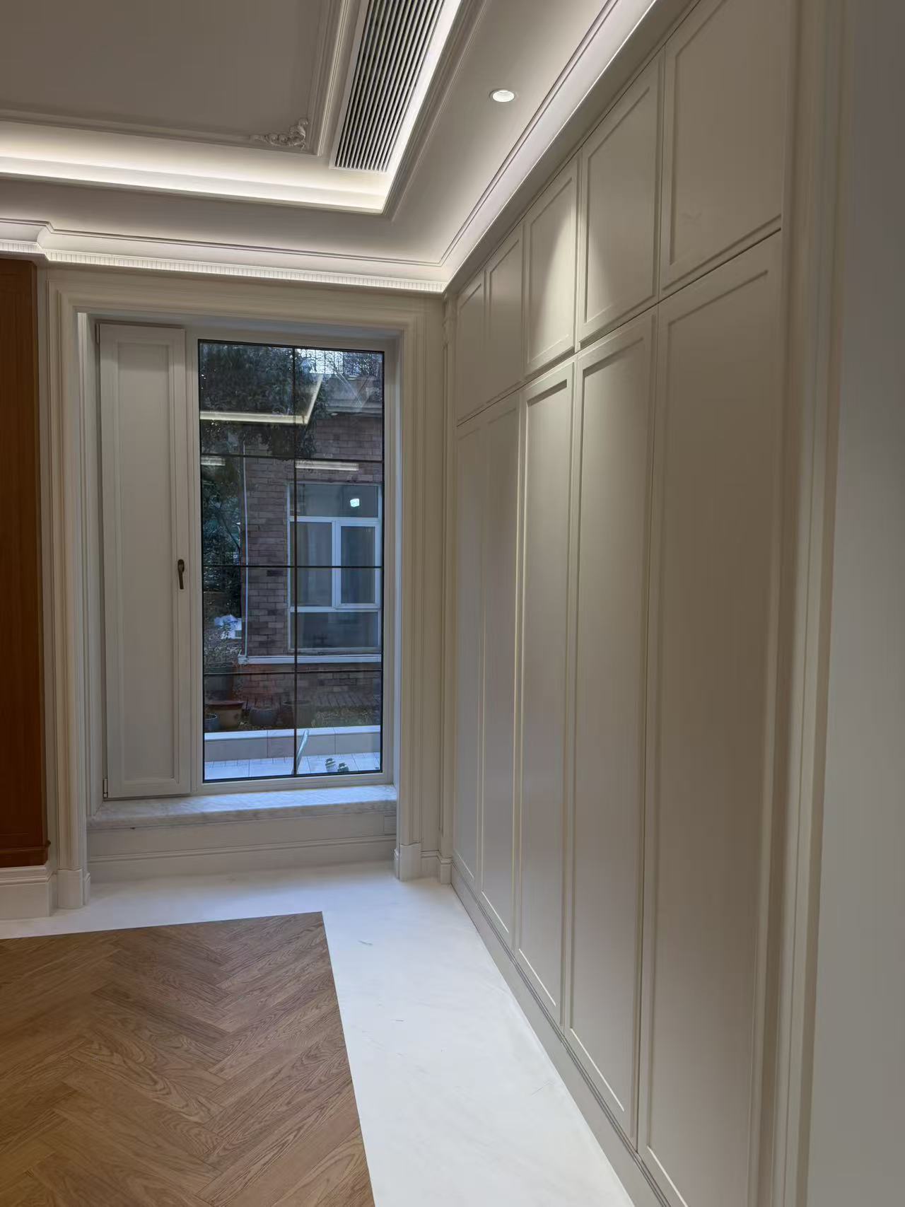 Living room with full-wall custom cabinetry and wall paneling