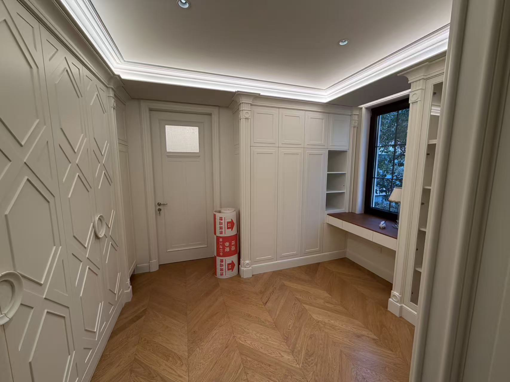 Walk-in closet with corner wardrobe cabinetry and desk