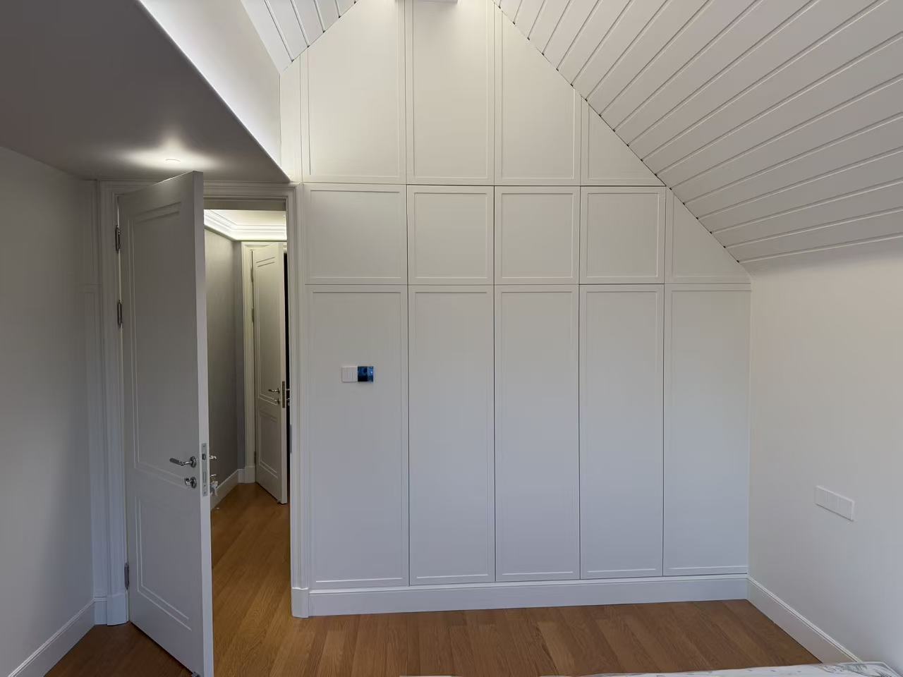 Bedroom with custom wardrobe adapted to the sloped ceiling
