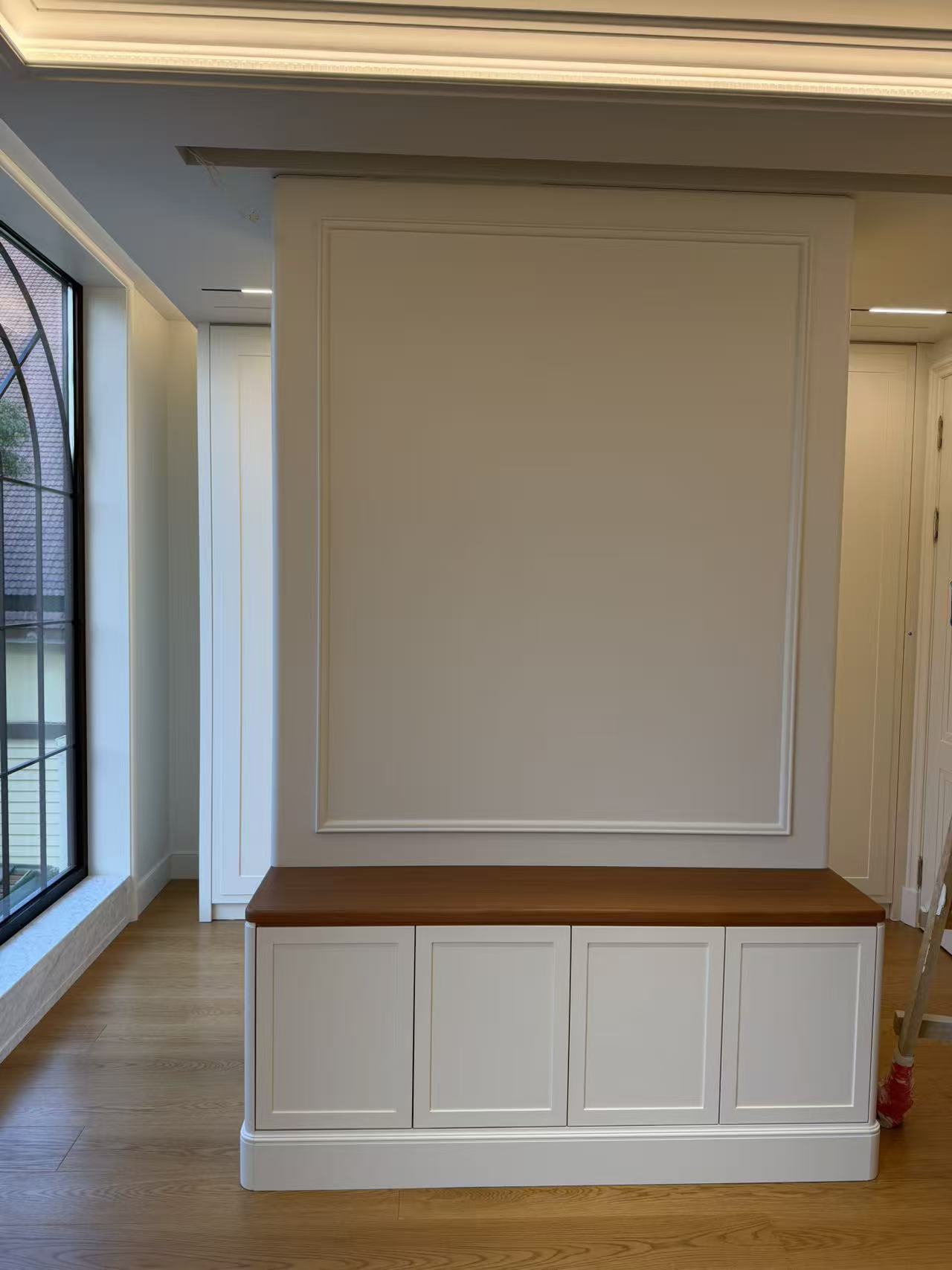 Entryway with custom low cabinet and wall paneling