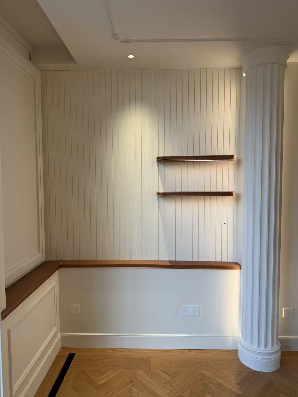 Entryway with vertical-groove wall paneling and wall shelf